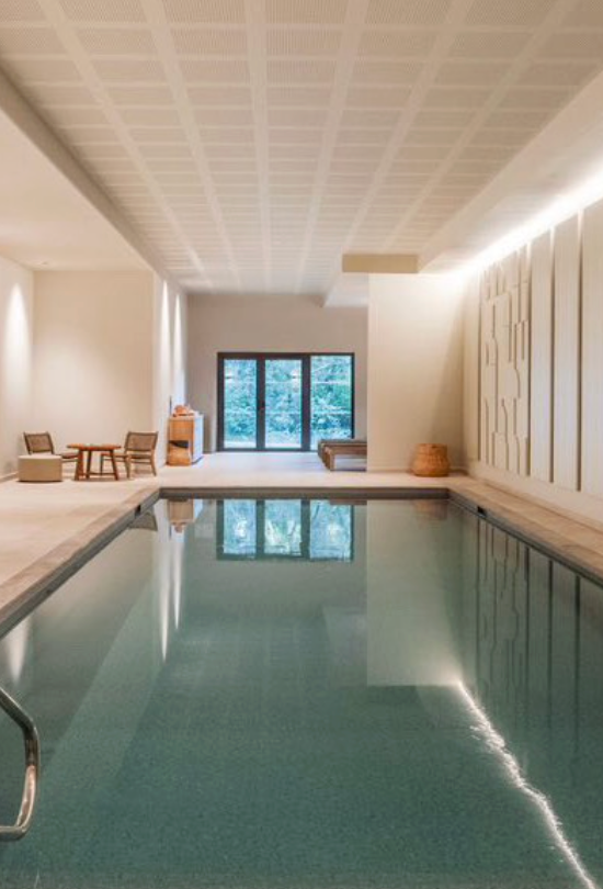 Indoor pool area with modern decor and large windows.