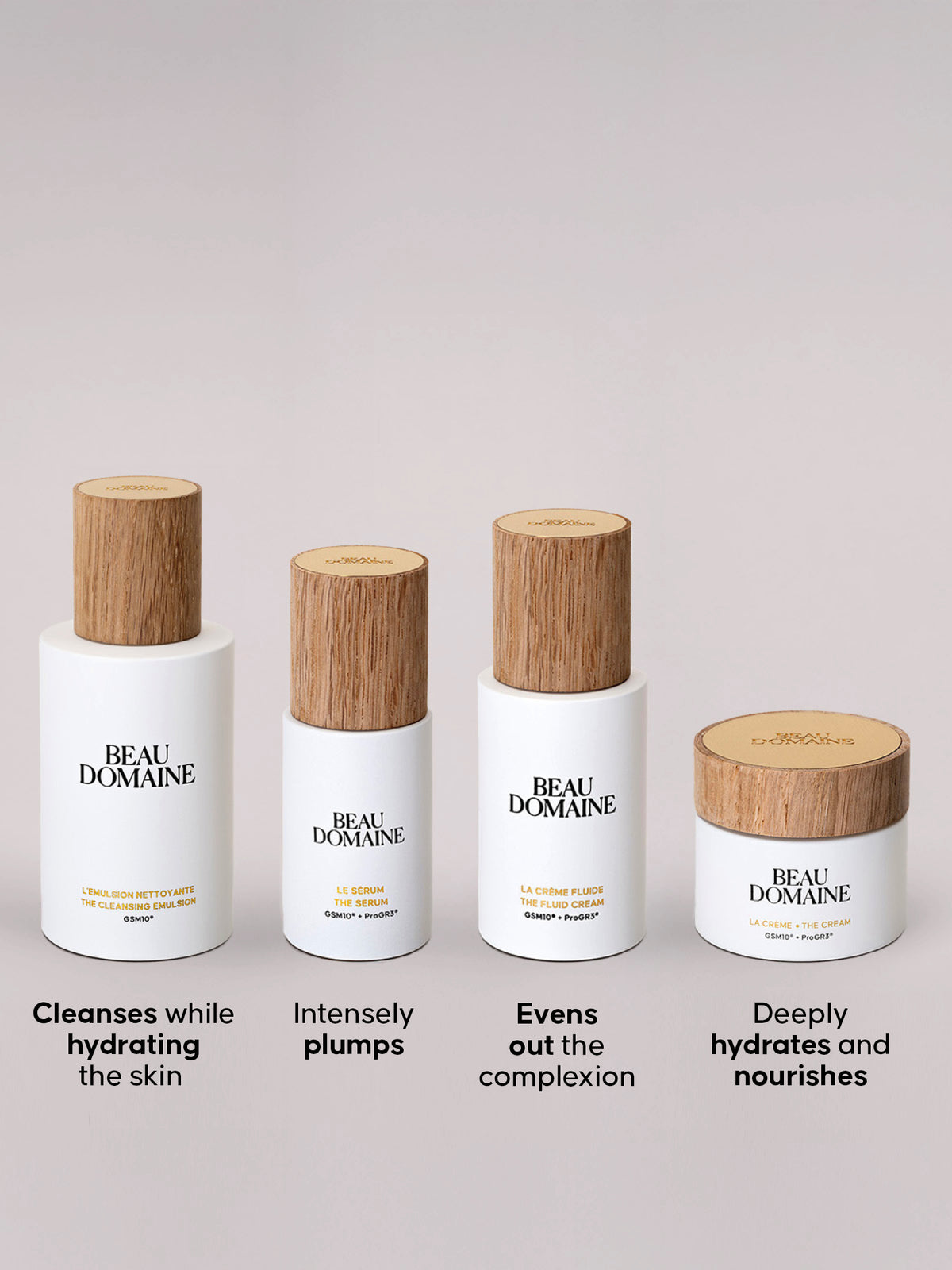 Set of skincare the four products included in The 2 Creams Routine, with wooden caps on a light gray background