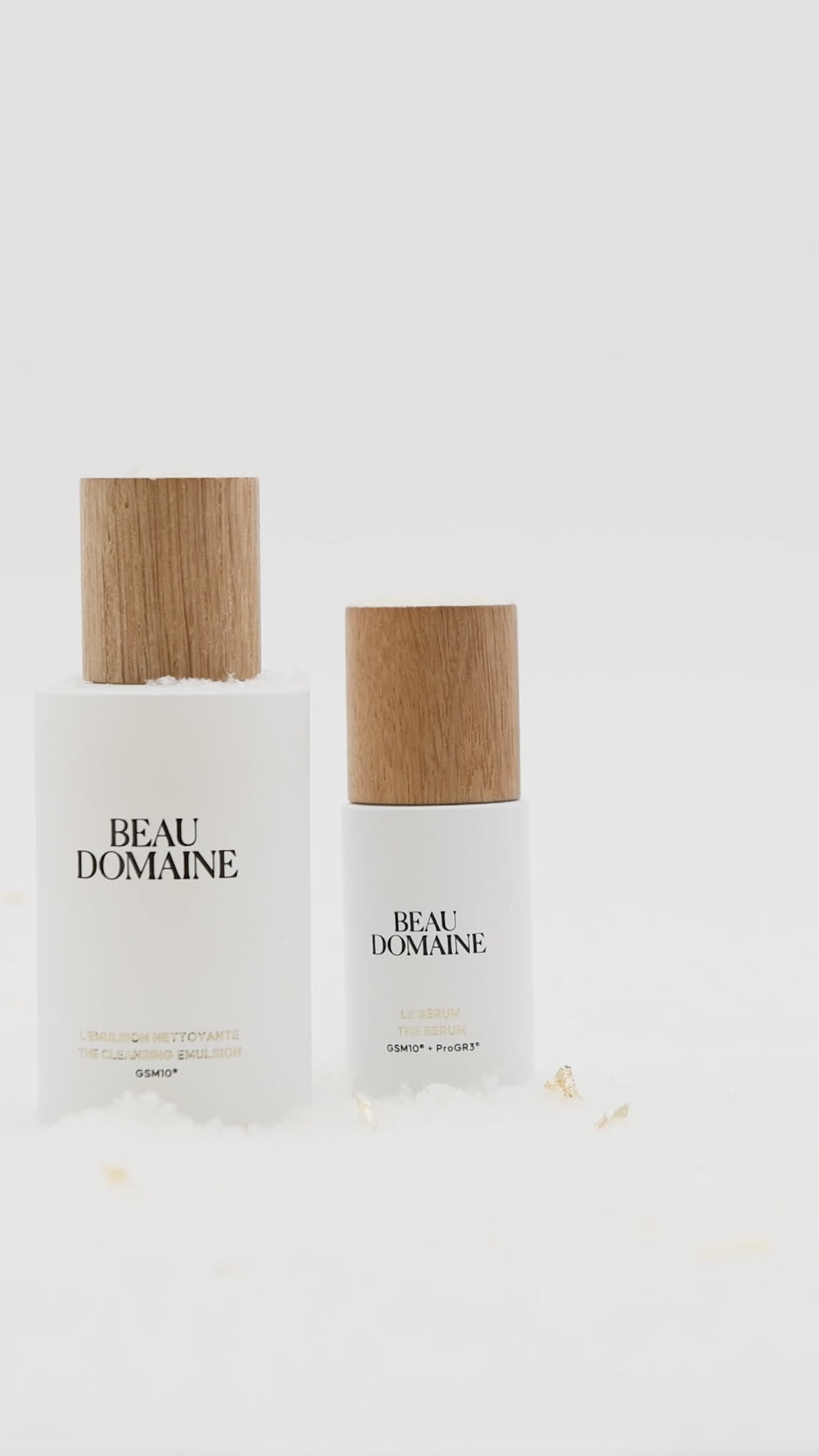 Short video showing an animation of La Routine Complète in the world of holiday celebrations, with products lined up against a clean white background and fake snow falling, with a hand placing the cream in the foreground